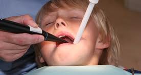 Дете с проблеми със зъбите седи в стоматологичен кабинет